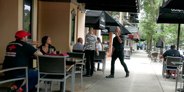 Customers enjoy sidewalk dinning in Orlando, Florida, Monday as restaurants could open at 50 percent capacity. (AP Photo/John Raoux)