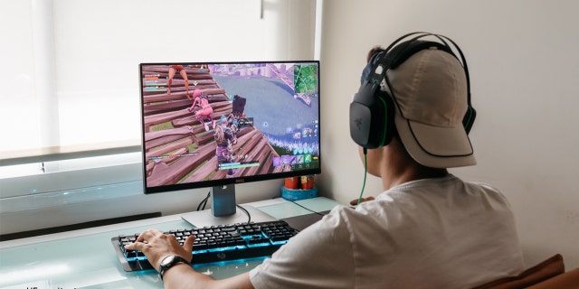 Tínedžer hrá videohru Fortnite na PC.  Fortnite je online videohra pre viacerých hráčov vyvinutá spoločnosťou Epic Games