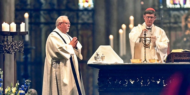 German Cardinal and Cologne Archbishop Rainer Woelki, right, celebrated the first church service at Germany's Cologne Cathedral on Sunday. (AP Photo/Martin Meissner)
