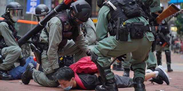 Riot police detain a protester during a demonstration against Beijing's national security legislation in Causeway Bay in Hong Kong, Sunday, May 24, 2020. (AP Photo/Vincent Yu)
