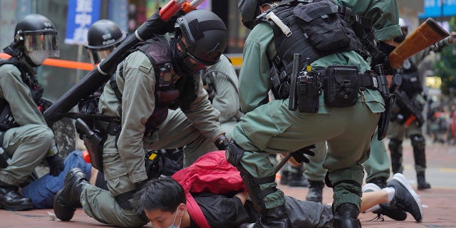 Riot police detain a protester during a demonstration against Beijing's national security legislation in Causeway Bay in Hong Kong, Sunday, May 24, 2020. (AP Photo/Vincent Yu)