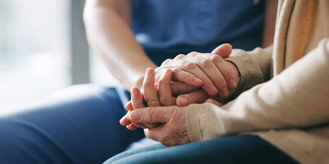 Image of a nurse comforter an elderly patient.