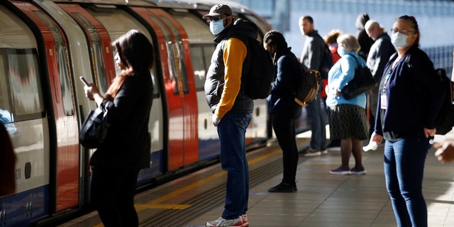 Commuters, some wearing masks are seen at Canning Town station, following the outbreak of the coronavirus disease (COVID-19), London, Britain, May 13, 2020.