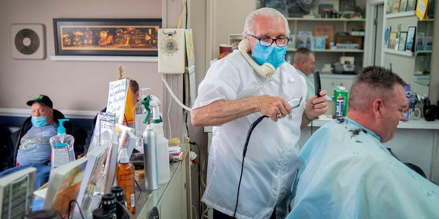 Manke has given over 100 haircuts, and fields more calls than that daily, all while continuing to cut hair. He has followed sanitary measures while working, including wearing a mask and sanitizing his tools with ultraviolet light.(Jake May/The Flint Journal via AP)