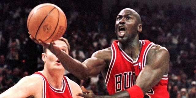 Michael Jordan (R) of the Chicago Bulls flies to the basket past Luc Longley 10 May in game four of their Eastern Conference semi-final against the Charlotte Hornets at the Charlotte Coliseum in Charlotte, NC.  