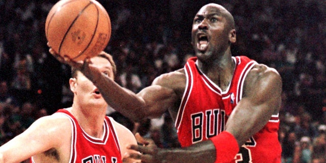 Michael Jordan (R) of the Chicago Bulls flies to the basket past Luc Longley 10 May in game four of their Eastern Conference semi-final against the Charlotte Hornets at the Charlotte Coliseum in Charlotte, NC.  