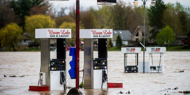 Floodwater surrounds gas pumps at Wixom Lake Gas & Launch May 19, along the Tittabawassee River in Beaverton, Mich.