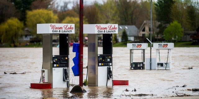 Floodwater surrounds gas pumps at Wixom Lake Gas & Launch May 19, along the Tittabawassee River in Beaverton, Mich.