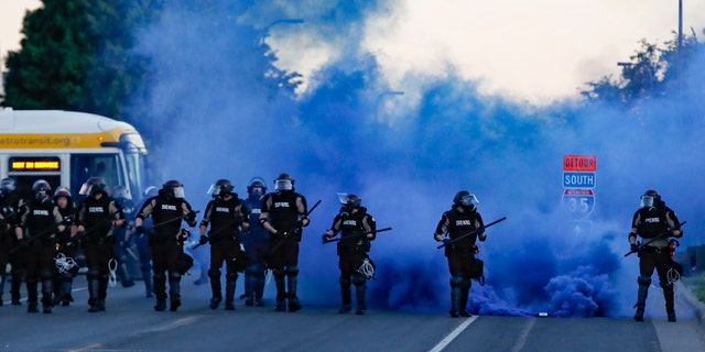Police in riot gear prepares to advance on protesters, Saturday, May 30, 2020, in Minneapolis.