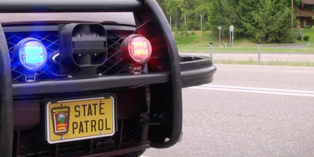 A Minnesota State Patrol patrol car is stopped on the side of the road.