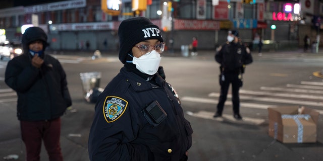 Police officers patrol a quiet street on foot April 22, during the coronavirus pandemic, in the Bronx borough of New York. As President Trump aims for a swift nationwide reopening, he faces a new challenge: convincing people it's safe to come out and resume their normal lives. (AP Photo/Mark Lennihan)