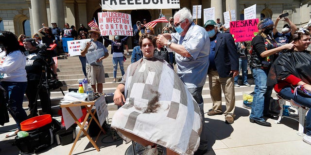 Manke gave free haircuts outside the Capital in Lansing as part of "Operation Haircut" on May 20. (AP Photo/Paul Sancya)