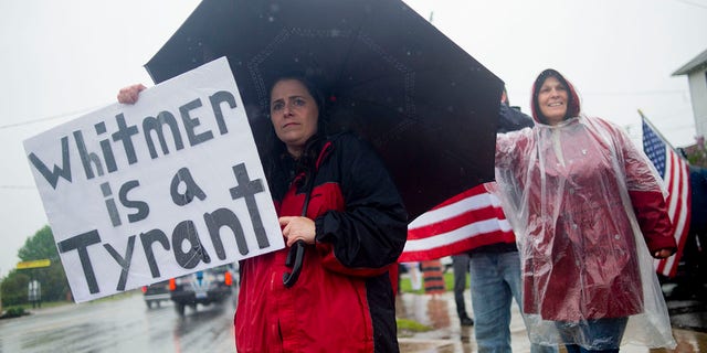 Michigan residents gather in protest of Whitmer's restrictions before a press conference featuring Texas hairstylist Shelley Luther, barber Karl Manke and others on Monday outside Manke's shop. (Jake May/The Flint Journal via AP)
