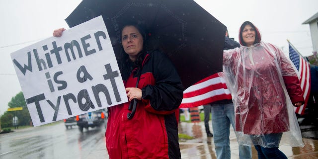 Michigan residents gather in protest of Whitmer's restrictions before a press conference featuring Texas hairstylist Shelley Luther, barber Karl Manke and others on Monday outside Manke's shop. (Jake May/The Flint Journal via AP)