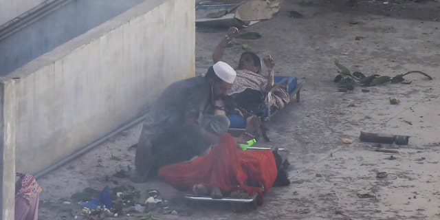 A man helps injured victims after a Pakistan International Airlines flight crashed in a residential neighbourhood in Karachi on May 22, 2020.