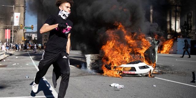 Smoke rises from a fire on a police cruiser in Center City during the Justice for George Floyd Philadelphia Protest on Saturday, May 30, 2020, in Philadelphia.