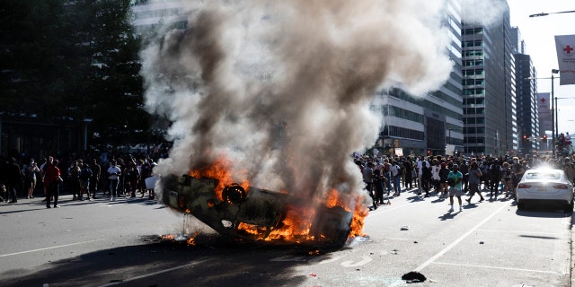 Smoke rises from a fire on a police cruiser in Center City during the Justice for George Floyd Philadelphia Protest on Saturday, May 30, 2020, in Philadelphia.