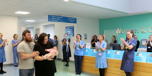 Katherine and Stuart Dawson are applauded as they leave Blackpool Victoria Hospital with baby Ruby.