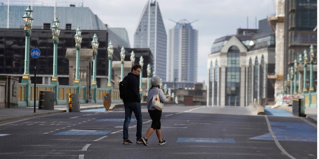 Pedestrians cross the road on Southwark Bridge during the morning rush hour in London as the country continues in lockdown to help stop the spread of coronavirus, Monday, May 11, 2020. Britain's Prime Minister Boris Johnson announced Sunday that people could return to work if they could not work from home. (AP Photo/Kirsty Wigglesworth)