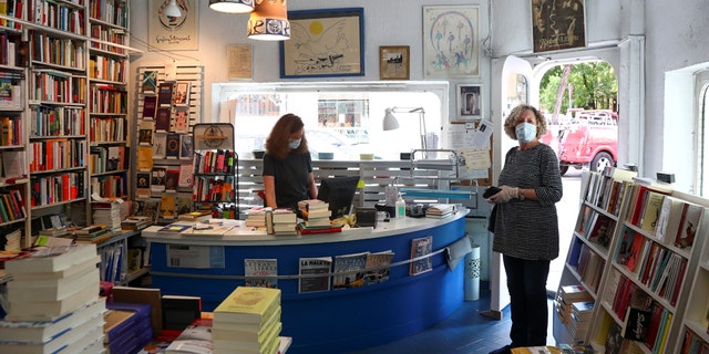 Lola Larumbe attends a customer inside her Rafael Alberti book shop amid the coronavirus disease (COVID-19) outbreak in Madrid, Spain, May 5, 2020.