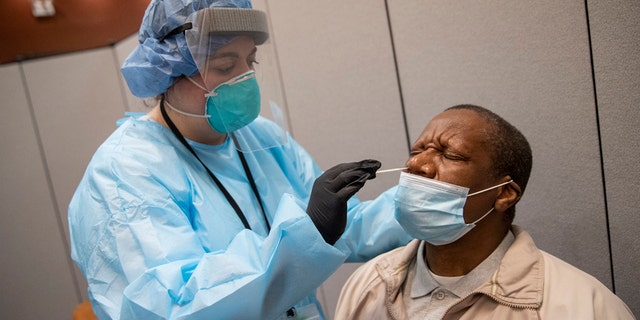 Registered nurse Stephanie Mundo conducts a COVID-19 test at the Abyssinian Baptist Church, Wednesday, May 13, 2020, in the Harlem neighborhood of New York.