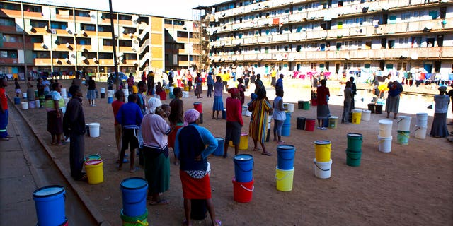 In this April 24 photo, people wait to fetch water from a row of communal taps that the group Doctors Without Borders provided in a suburb of Harare, Zimbabwe. For people around the world who are affected by war and poverty, the simple act of washing hands is a luxury, even during the coronavirus pandemic. In Zimbabwe, clean water is often saved for daily tasks like doing dishes and flushing toilets. (AP)