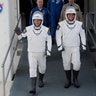 NASA astronauts Douglas Hurley and Robert Behnken wave as they walk out of the Neil A. Armstrong Operations and Checkout Building on their way to Pad 39-A, at the Kennedy Space Center in Cape Canaveral, Florida, May 27, 2020. 