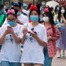 Visitors, wearing face masks, enter the Disneyland theme park as it reopened in Shanghai, May 11, 2020. 