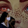 Women wear face masks as they wait for a test at a COVID-19 testing site in the Estrutural neighborhood of Brasilia, Brazil, May 26, 2020. 