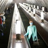 People wearing face masks and gloves to protect against coronavirus, observe social distancing guidelines as they go down the subway on the escalator in Moscow, May 12, 2020.