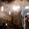 A man sprays disinfectant as he sanitizes Santa Maria in Trastevere Basilica to prevent the spread of COVID-19, in Rome, May 13, 2020. 