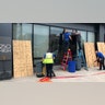 Workers repair smashed windows at a building south of downtown on Friday, May 29, 2020, in Columbus, Ohio. Multiple downtown storefronts had their windows smashed and some businesses were looted early Friday.