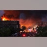 Seen from Hiawatha Avenue, a large fire burns Thursday, May 28, 2020, in Minneapolis during a third night of unrest following the death of George Floyd.