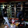 People take items from a liquor store Thursday, May 28, 2020, in Minneapolis. Protests over the death of George Floyd, a black man who died in police custody Monday, broke out in Minneapolis for a third straight night.