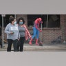 A person dressed as Spiderman sweeps the sidewalk as residents help to clean up following a night of rioting sparked by the death of George Floyd while in police custody on May 29, 2020 in Minneapolis.