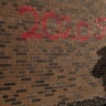 A man paints a message on the back of a store in Minneapolis during protests Wednesday, May 27, 2020, against the death of George Floyd in police custody earlier in the week.