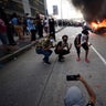 People pose for a photo in front of a burning police care in downtown Atlanta Friday.