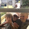 Virginia Smith, 95-year-old mother of four, 11 grandchildren and 17 great grandchildren, waves to two of her great grandchildren with their mother (l to r: Graham, Brinley, and Andrew) through the window of her daughter’s home in Jensen Beach FL. She would much rather be giving them a hug and a kiss than waving through the window but is doing her part and remaining isolated from the community.