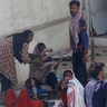Residents of an area hit by a plane crash wait for medical help in Karachi, Pakistan, Friday, May 22, 2020. (AP Photo/Fareed Khan)