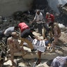 Volunteers cover the dead body of a plane crash victim at the site of the crash in Karachi, Pakistan, Friday, May 22, 2020. (AP Photo/Fareed Khan)