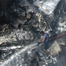 A firefighter tries to put out fire caused by plane crash in Karachi, Pakistan, Friday, May 22, 2020.  (AP Photo/Fareed Khan)