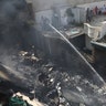 Fire brigade staff try to put out fire caused by plane crash in Karachi, Pakistan, Friday, May 22, 2020.  (AP Photo/Fareed Khan)