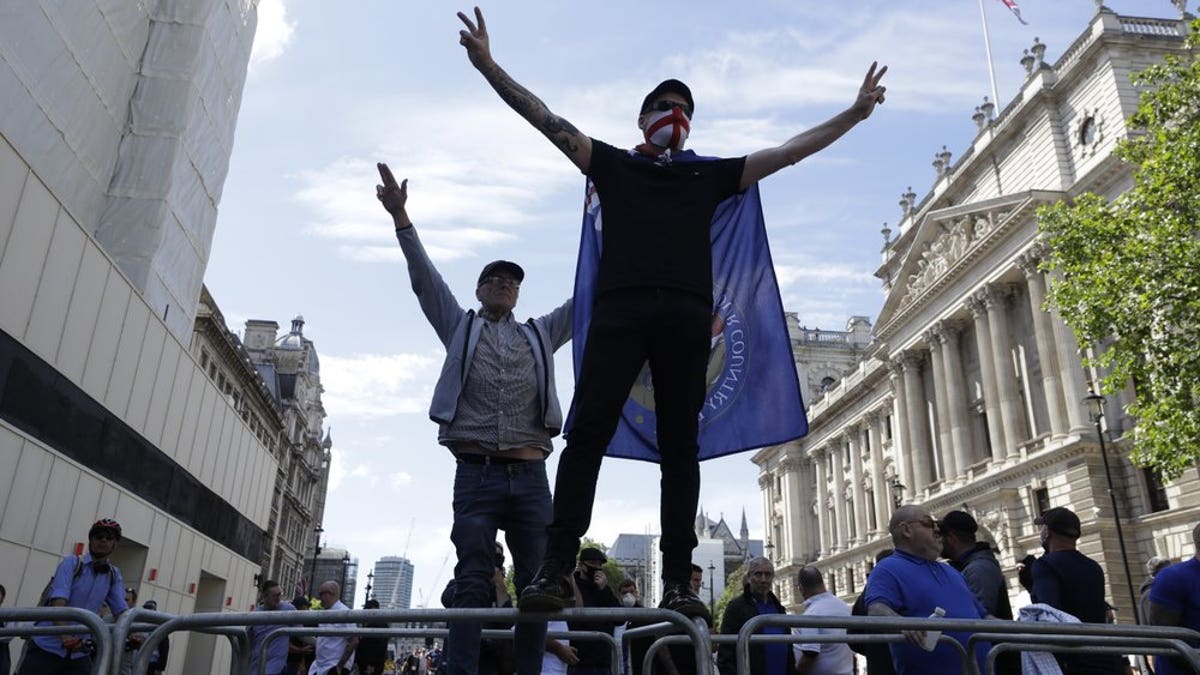 Members of Football Lads Alliance, standing at a police barrier along Whitehall, in central London, chant slogans, Saturday, June 13, 2020.