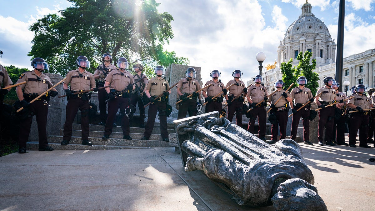 Minnesota State Troopers surrounded the statue of Christopher Columbus after it was toppled in front of the Minnesota State Capitol, Wednesday, June 10, 2020, in St. Paul, Minn. The statue was later towed away. (Leila Navidi/Star Tribune via AP)