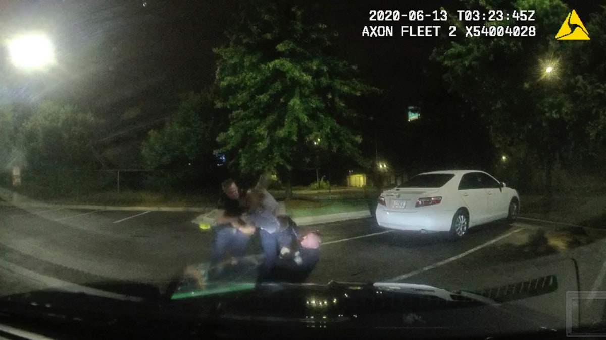 This screengrab taken from dashboard camera video provided by the Atlanta Police Department shows Rayshard Brooks, center, struggling with Officers Garrett Rolfe, left, and Devin Brosnan in the parking lot of a Wendy's restaurant, early Saturday, June 13, 2020, in Atlanta. (Atlanta Police Department via AP)