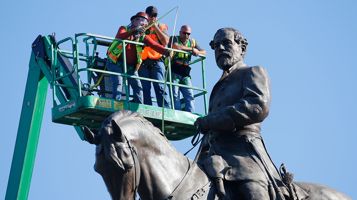An inspection crew from the Virginia Department of General Services takes measurements as they inspect the statue of Confederate Gen. Robert E. Lee on Monument Avenue Monday June 8, 2020, in Richmond, Va. (AP Photo/Steve Helber)