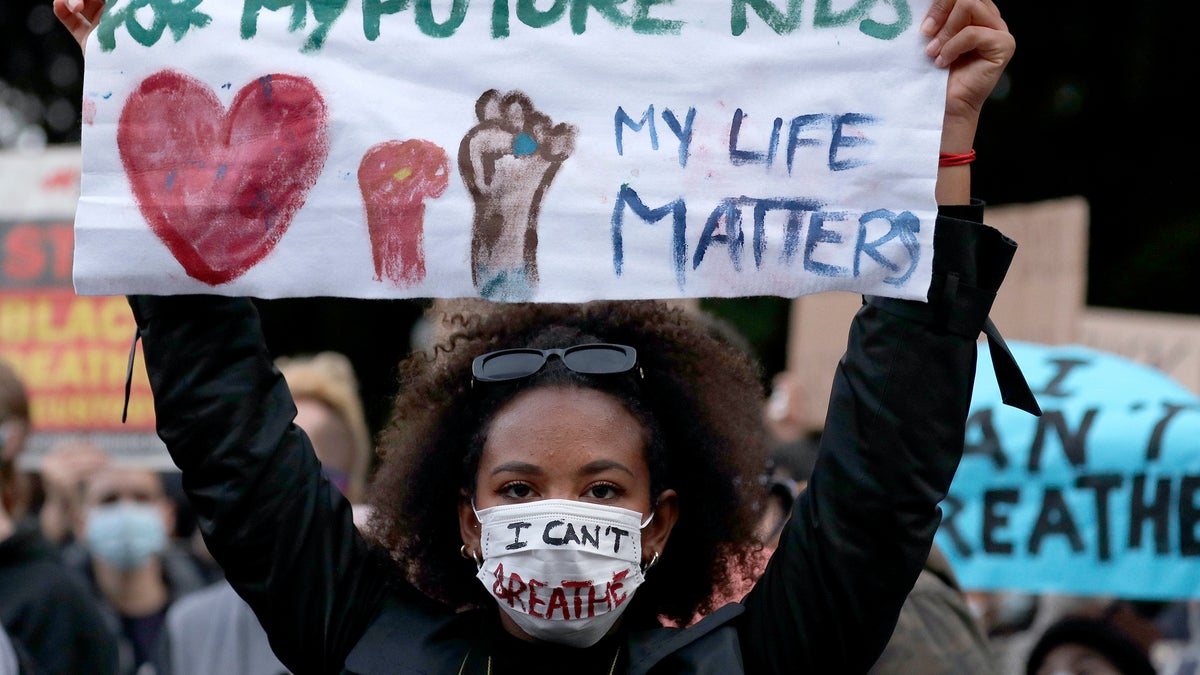 A woman holds a sign as protestors gather in Sydney, June 2 to support the cause of U.S. protests over the death of George Floyd and urged their own governments to address racism and police violence. Floyd died last week after he was pinned to the pavement by a white police officer who put his knee on the handcuffed black man’s neck until he stopped breathing. (AP Photo/Rick Rycroft)