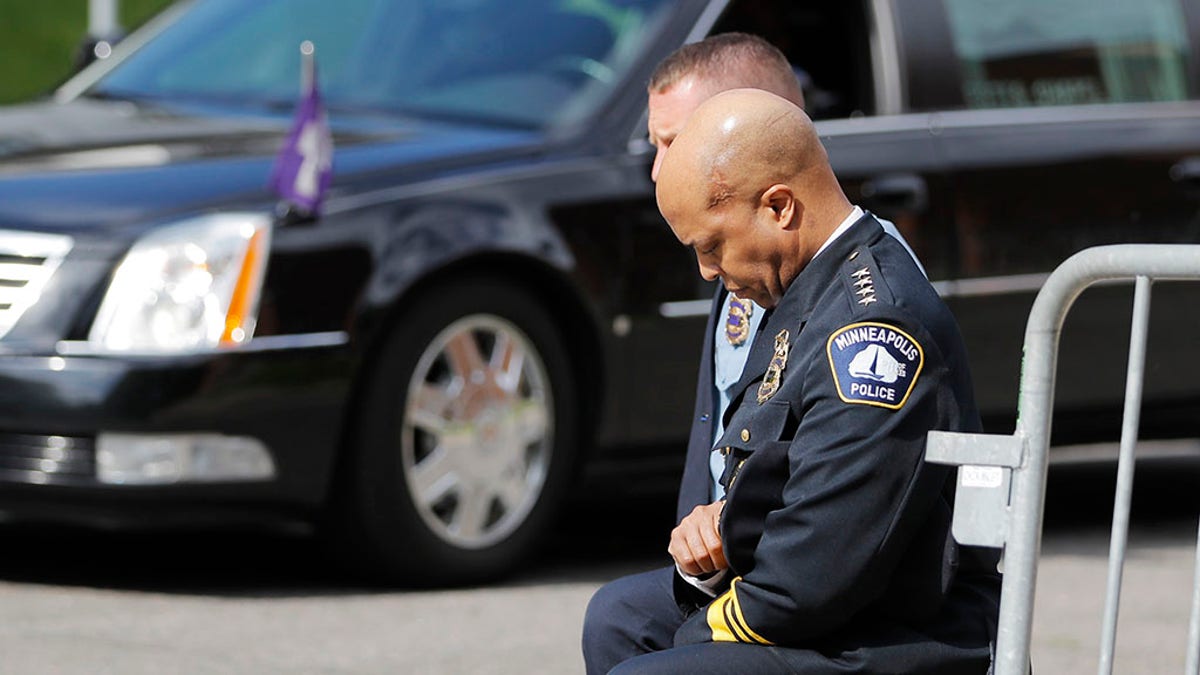 Police officers including Minneapolis Police Chief Medaria Arradondo, foreground, take a knee as the body of George Floyd arrives before his memorial services on Thursday, June 4, 2020 in Minneapolis. (AP Photo/Julio Cortez)