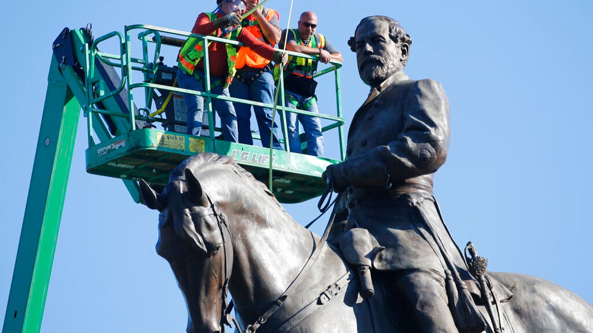 An inspection crew from the Virginia Department of General Services takes measurements as they inspect the statue of Confederate Gen. Robert E. Lee on Monument Avenue Monday June 8, 2020, in Richmond, Va. Virginia Gov. Ralph Northam has ordered the removal of the statue. (AP Photo/Steve Helber)