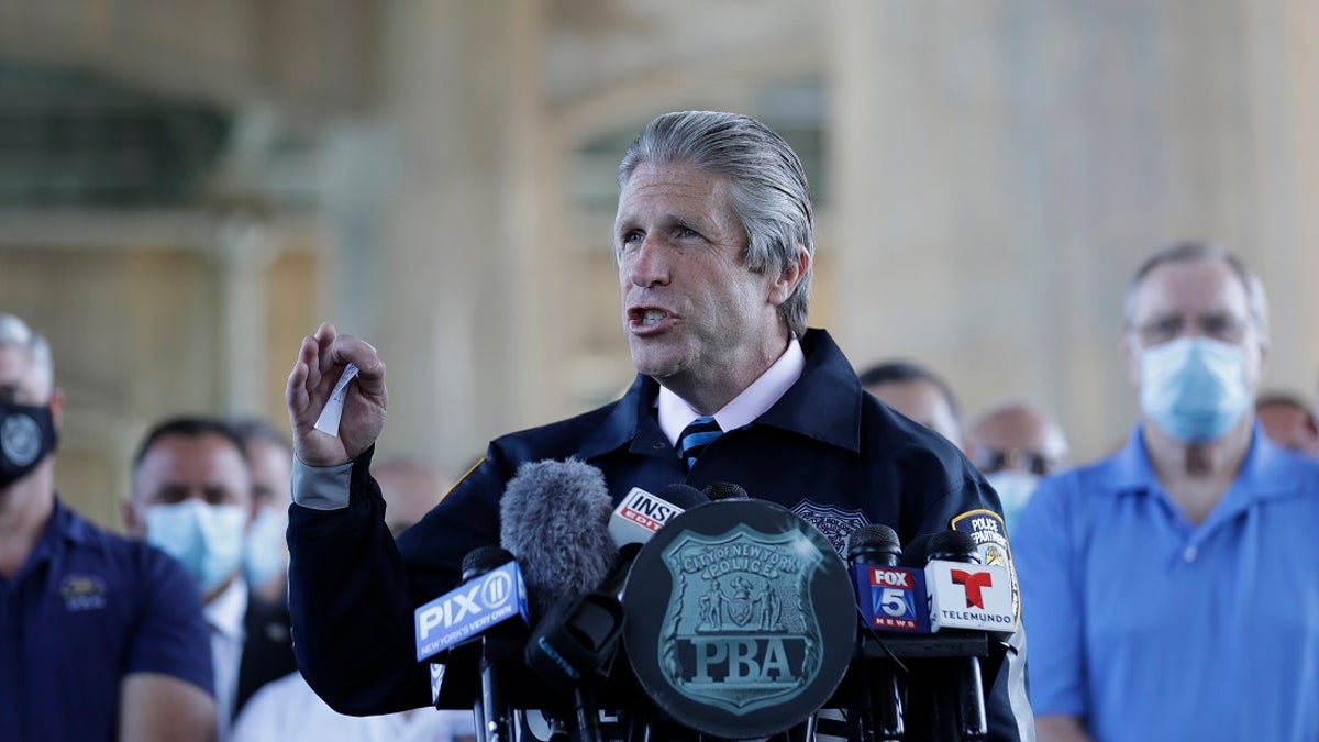 Surrounded by law enforcement and supporters, New York City PBA President Pat Lynch, center, speaks during a news conference in New York, Tuesday, June 9, 2020. (AP Photo/Seth Wenig)